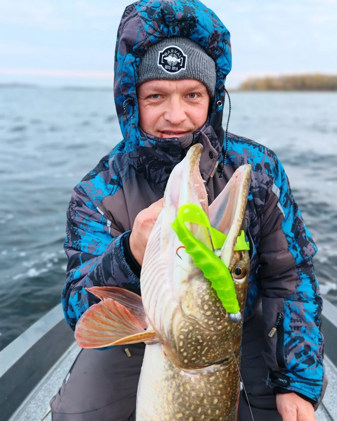 Рыболов со щукой на воде